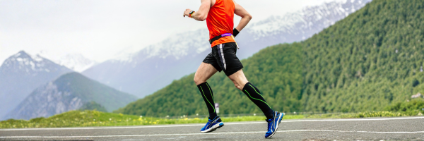 Man running outdoors wearing compression socks for leg support