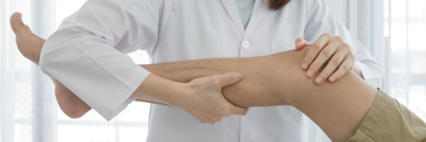Close-up of a healthcare provider performing a clinical leg examination
